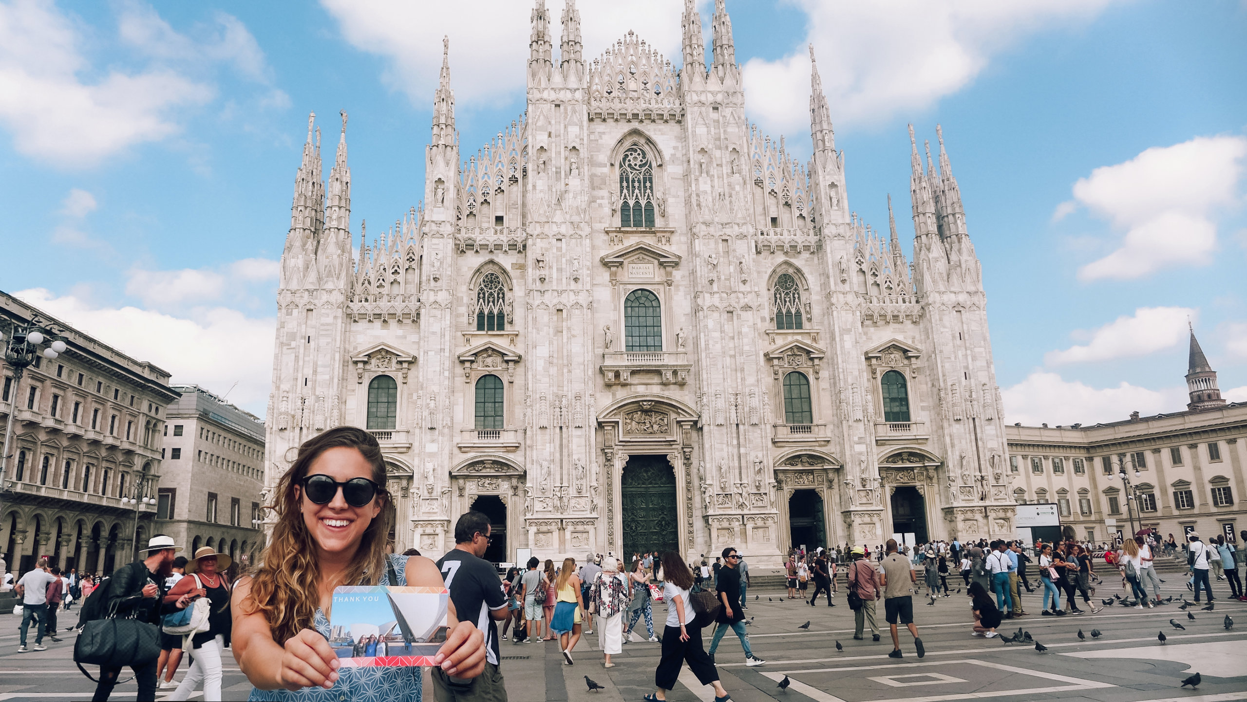 milan in front of the duomo cathedral holding a mixbook thank you card