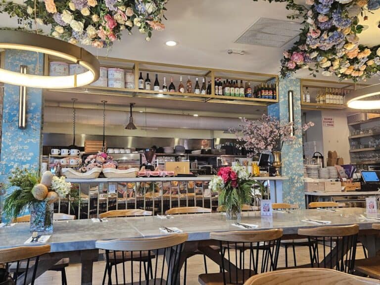 The interior of a restaurant in San Francisco with flowers hanging from the ceiling, serving the best breakfast.
