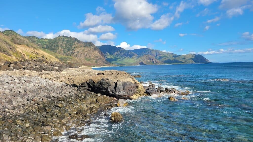 A rocky shoreline with mountains in the background, perfect for couples to enjoy a romantic stroll or picnic.