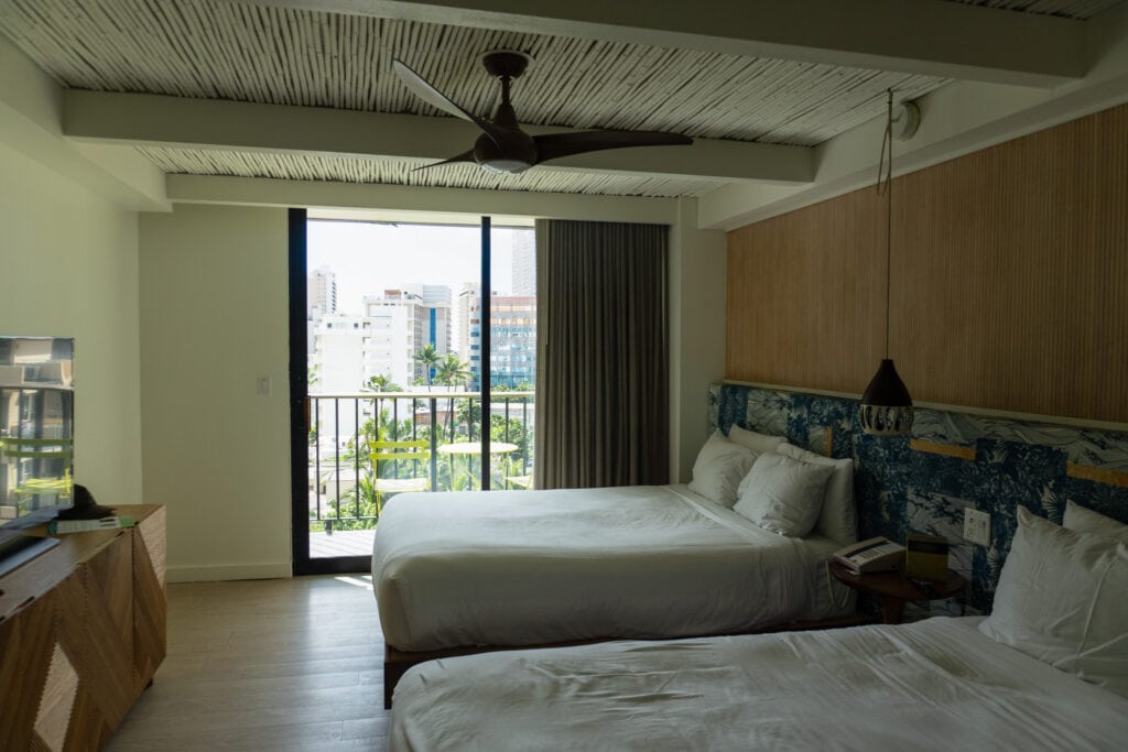 A room with two beds and a tv.