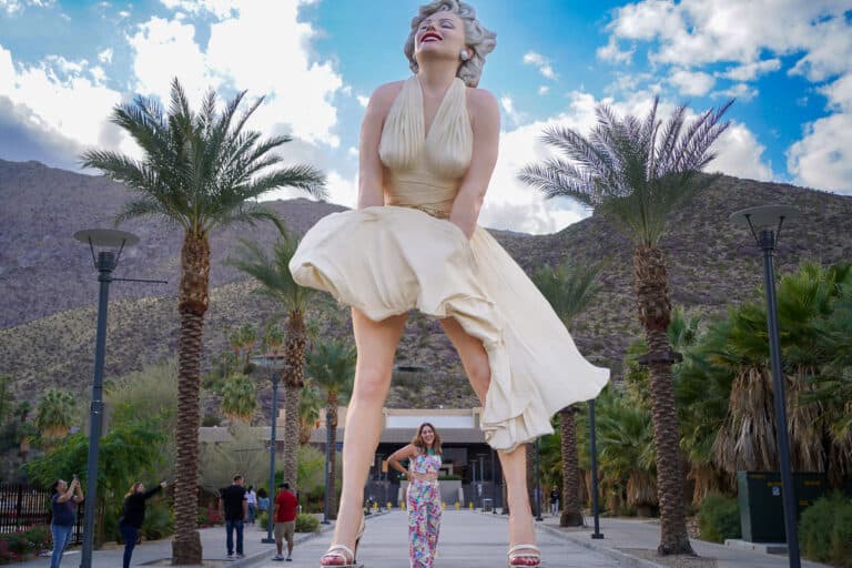 The best tours of Palm Springs include a Marilyn Monroe statue in Palm Springs, standing in front of palm trees.