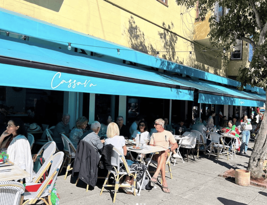 A group of people enjoying the best breakfast in San Francisco at tables outside a restaurant.