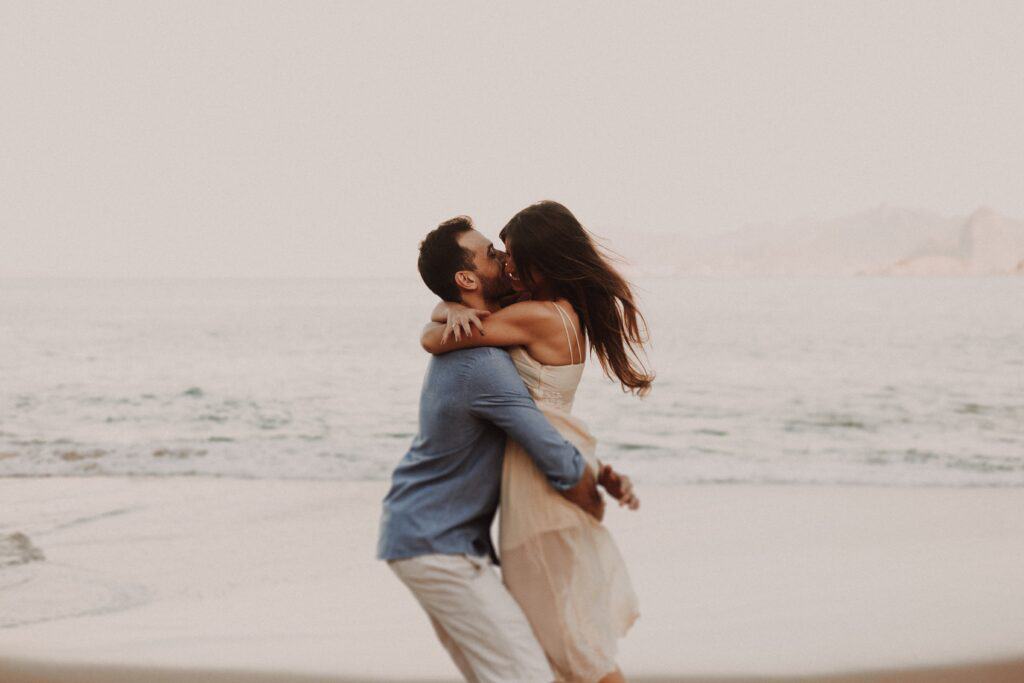 A man and woman sharing an affectionate embrace on the picturesque beaches of Oahu, one of the most romantic things to do in Oahu for couples.