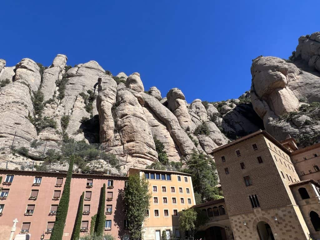 Buildings with a mountainous backdrop under a clear blue sky, perfect for any Montserrat itinerary.