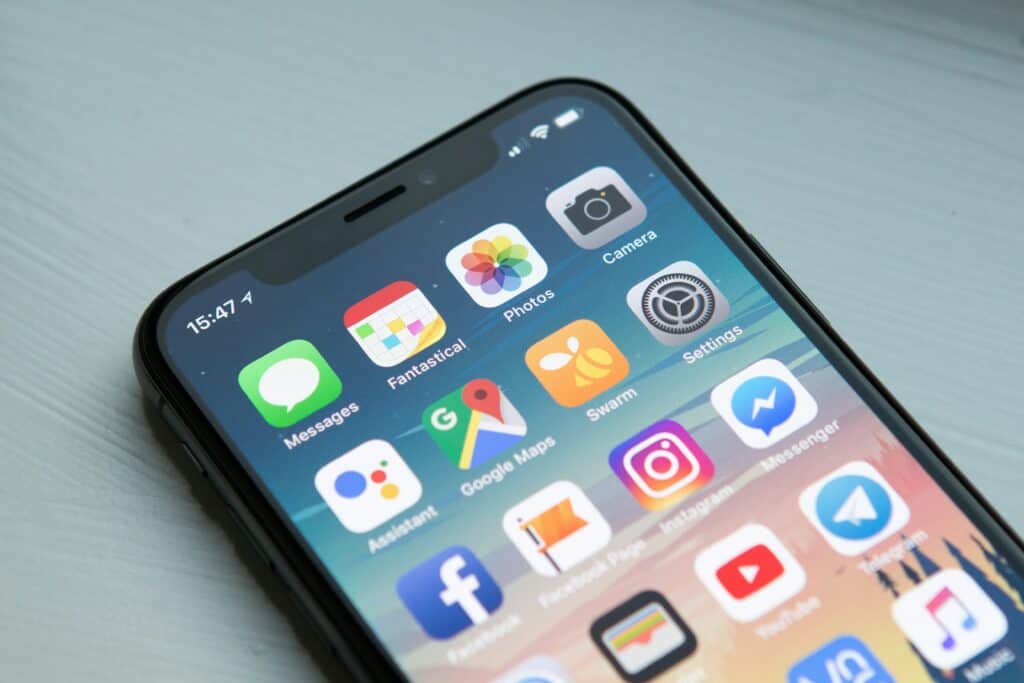 Close-up of a smartphone displaying various app icons, such as Messages, Photos, and Camera, with the time showing 15:47 in the top left corner. Perfect for digital nomads, it also supports eSIMs for seamless connectivity anywhere.