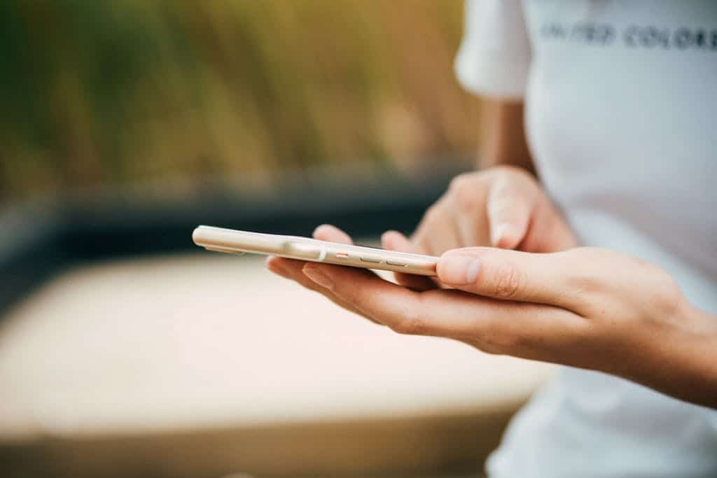 A person holding and using a smartphone, possibly activating an eSIM for Europe, with only their hands and part of a white shirt visible in the image.