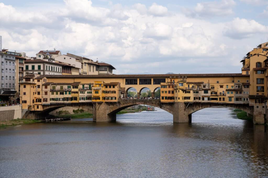 The multi-story buildings of the Ponte Vecchio bridge spanning the Arno River, a highlight to see during 3 days in Florence.