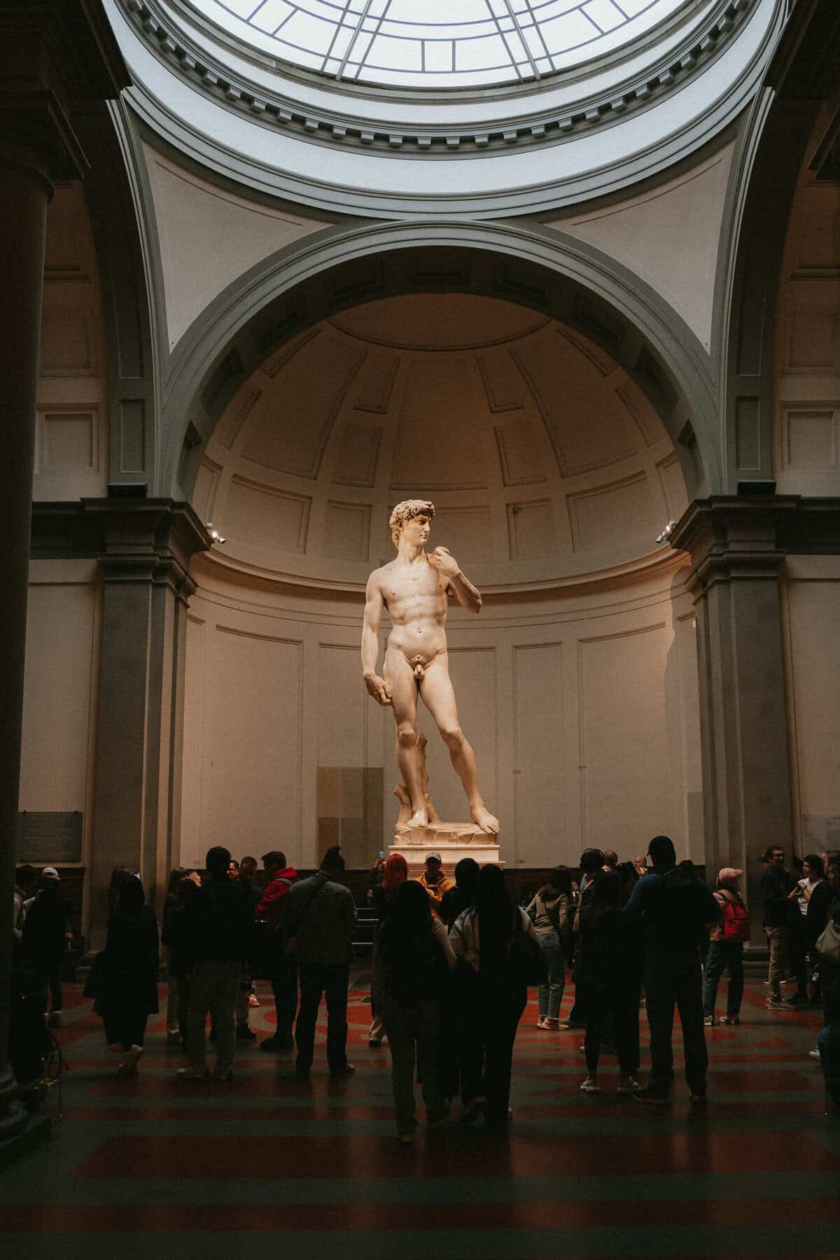 Michelangelo’s statue of David stands in a gallery under a domed ceiling, a must-see highlight for any 3 days in Florence itinerary as visitors gather to admire the masterpiece.
